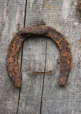  	Vintage horseshoe nailed at old wooden wall