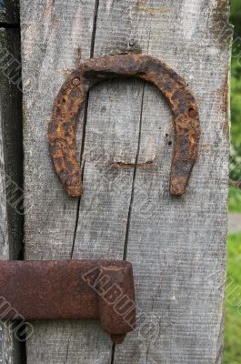  	Vintage horseshoe nailed at old wooden wall