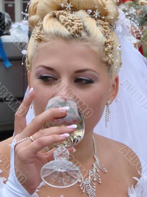 Young bride drinking champagne