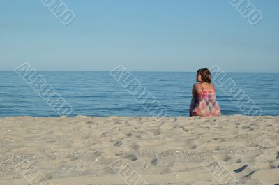 Young woman is sitting on the beach 2
