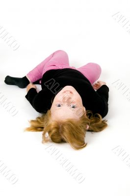 little girl is laying on floor