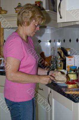 elderly woman is making sandwiches