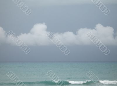 withe puffy clouds above turquoise