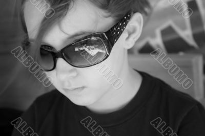 Young girl glaring over black sunglasses