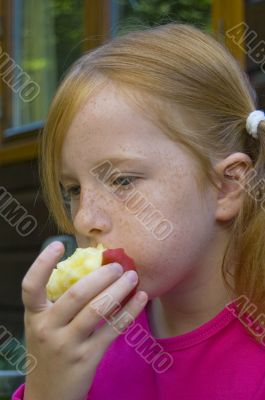 little girl is eating an apple