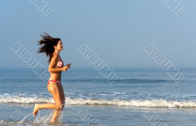 Beautiful girl running on the beach