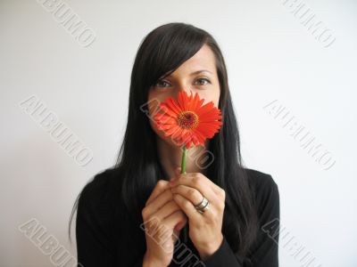 a pretty girl with a orange flower