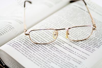 Glasses and the opened book