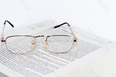Glasses on the opened page of the book