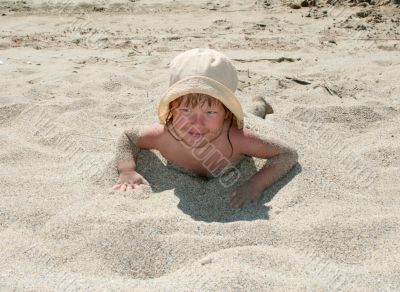 Baby girl plays with a sand