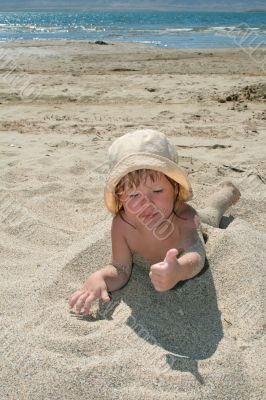 Baby girl plays with a sand