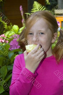 little girl is eating an apple