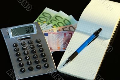 Money, notebook, calculator and pencil