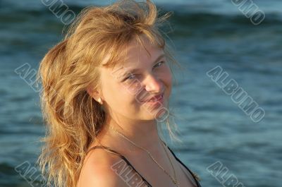 Beautiful blond girl stands near the river