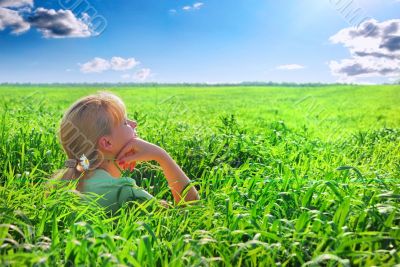 Relaxing girl on meadow against the blue sky