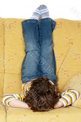 Boy lying down on the sofa at home