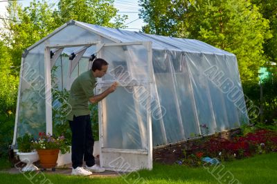 Man Painting Greenhouse