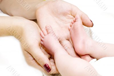 Mother holding her child`s feet