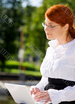 businesswoman with laptop in the park