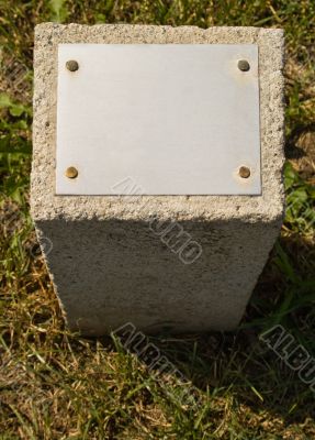 Concrete stone with a metal plate for an inscription
