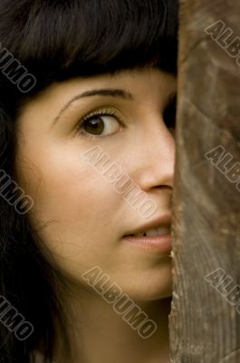 girl hiding behind a tree
