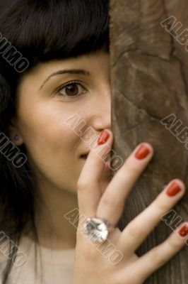 girl hiding behind a tree