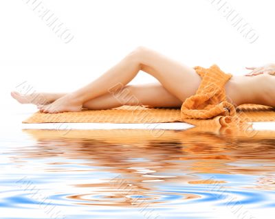 long legs of relaxed lady with orange towel