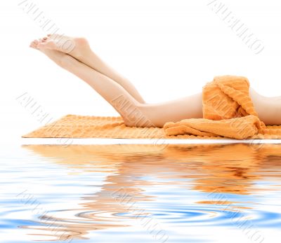 long legs of relaxed lady with orange towel