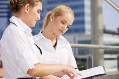 two happy businesswomen with paper chart