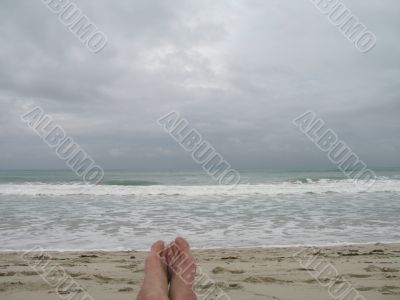 man`s feet on the beach