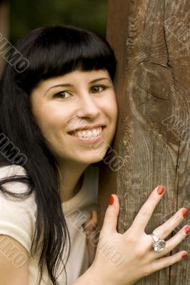 happy girl hiding behind a tree