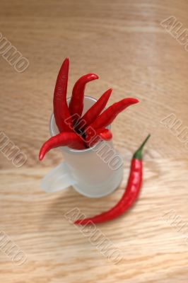 red peppers in a frosted glass on wood table