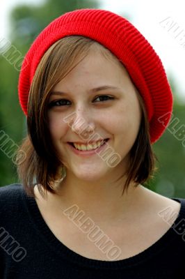 Portrait of a young girl with red cap.