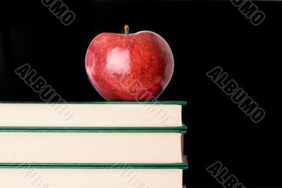 A red apple red on a green book