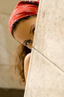 woman looking behind a wal