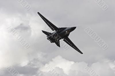 A Jet Fighter Airborne Against A Cloudy Sky