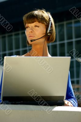 Young woman with a laptop and headset