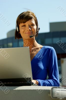 Young woman with a laptop and headset