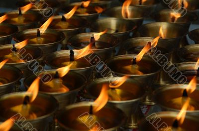 Many burning candles in row in biddhist church