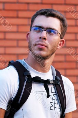 Man in glasses at the brick wall background