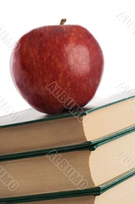 A red apple on top of books