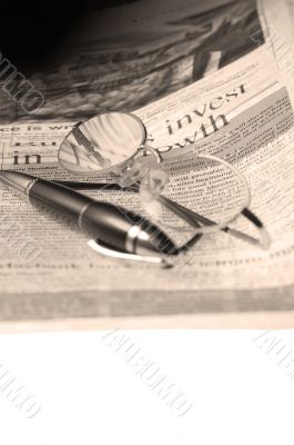 pen and glasses and newspaper