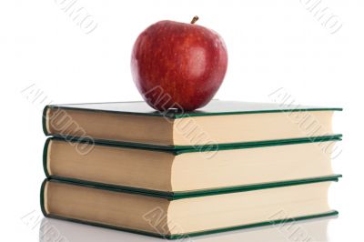 A red apple on top of three books
