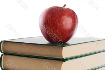 A red apple on top of books