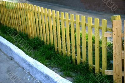 Yellow fence and the green grass
