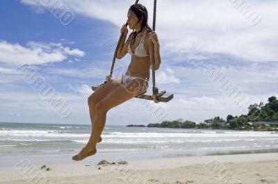 Girl on swing on the beach