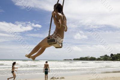 Girl on swing on the beach