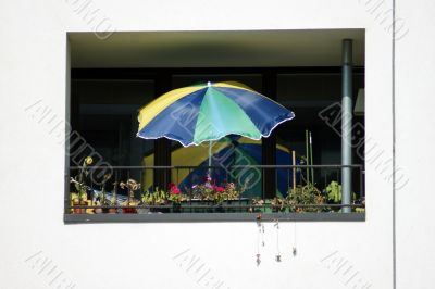 Balcony with a sun umbrella and flowers