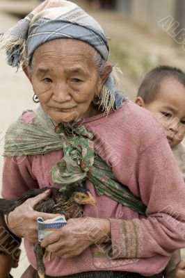 Asia, old woman with chicken and grandson