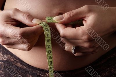 woman measure belly with tape